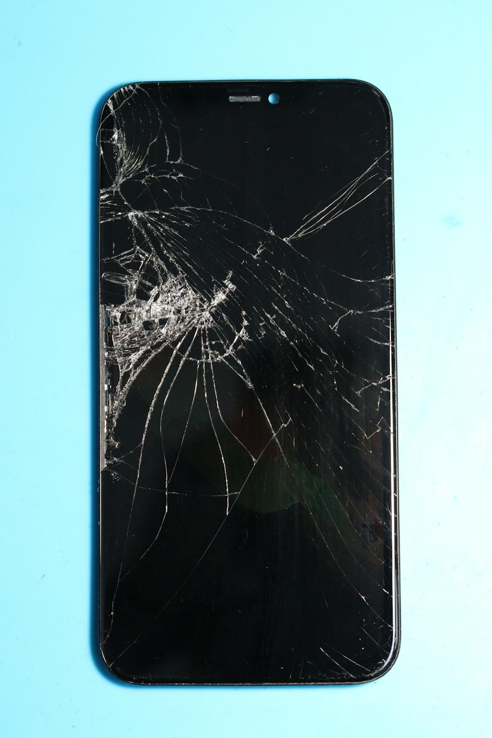 Celular con la pantalla trizada sobre un fondo celeste en Rancagua